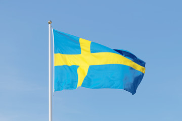 Swedish flag, blue and a yellow cross, blue sky