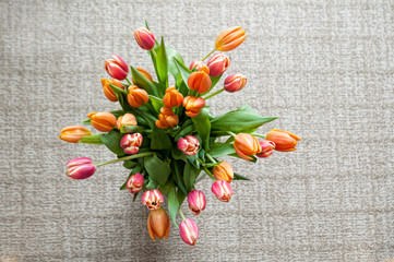 bunch of orange and pick tulips against a textured background