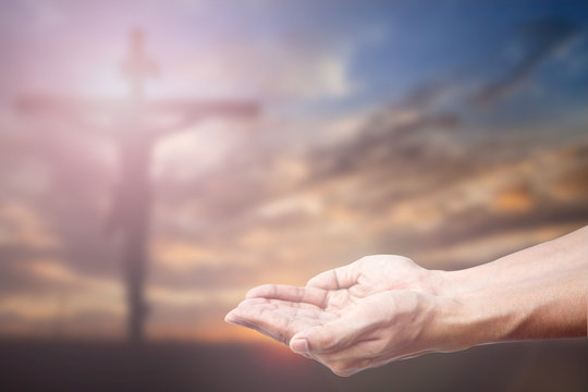 Praying Hand and the cross blurred background