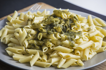 Italian penne pasta with green pesto sauce