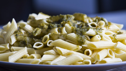 Italian penne pasta with green pesto sauce