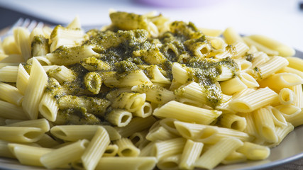 Penne pasta with green pesto sauce