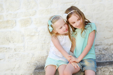 Two adorable little sisters laughing and hugging © MNStudio