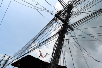Obraz premium Web of Cables Connecting to a Wooden Pole