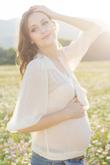 Fototapeta na wymiar Happy pregnant woman in sunset lights
