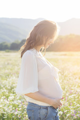 Fototapeta na wymiar Pregnant woman in sunset lights