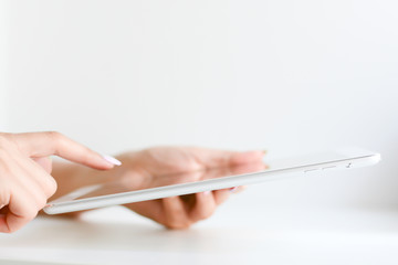 Woman hand browsing a digital tablet