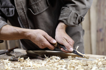 Fototapeta na wymiar carpenter with chisel in the hands on the workbench in carpentry