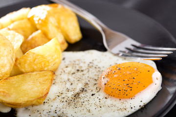 One fried egg with potatoes