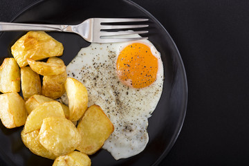 One fried egg with potatoes