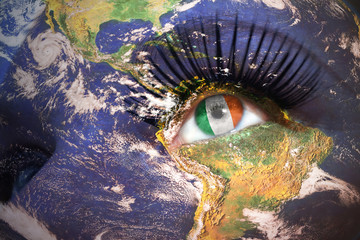woman's face with planet Earth texture and irish flag inside the eye