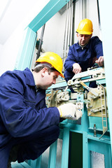 machinist with spanner adjusting lift mechanism © Kadmy