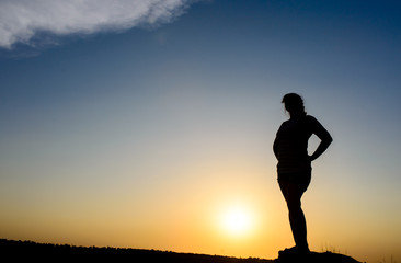 Fototapeta premium Woman embracing the sunset