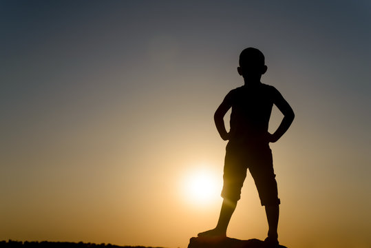 Silhouette of Boy Standing with Hands on Hips