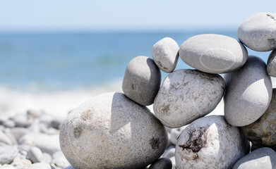 Fototapeta na wymiar Small Flat Rock Balancing on Rock Beach Wall