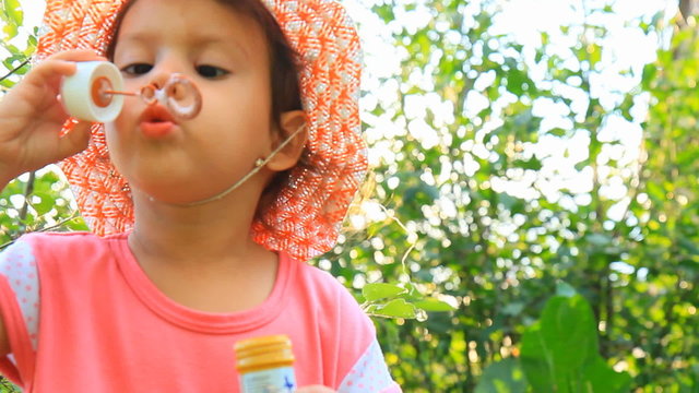 девочка надувает мыльные пузыри