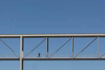 businessman walking over bridge 