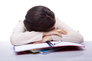 Tired female student sleeping at the desk, isolated on white bac