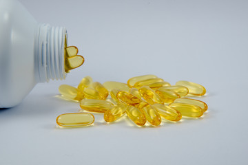 fishoil capsules from bottle in white background