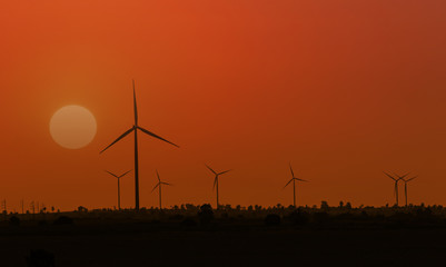 Obraz premium Silhouette wind turbine with sunset