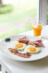 Breakfast with bacon , fried egg and orange juice