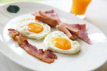 Breakfast with bacon , fried egg and orange juice