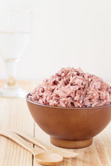 Bowl of steamed brown rice on wood table