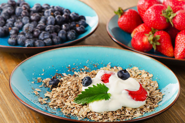 Fresh berries and muesli on a wooden table.