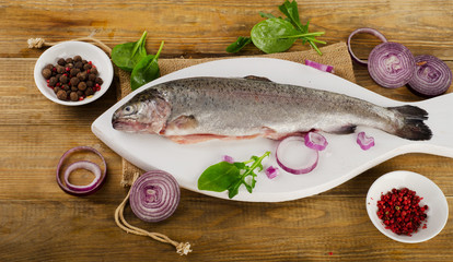 Raw Rainbow trouts on a  rustic wooden table.