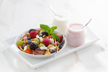 fruit salad and various yoghurt on a white wooden table