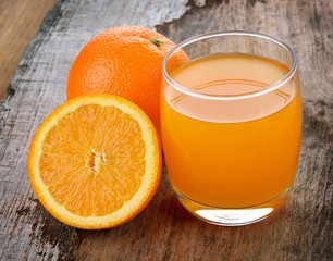 Orange juice on wooden background.