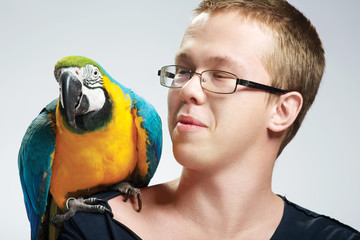 
happy young man with a parrot
