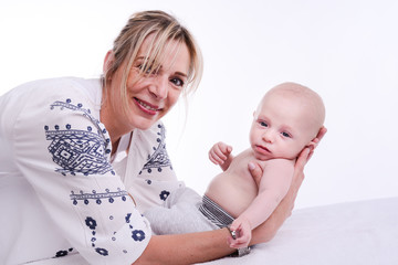 mature blonde woman playing and taking care of her lovely new born baby boy