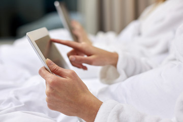 close up of woman hands in bathrobe with tablet pc