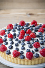Cake with blueberries and raspberries. Confectionery product.