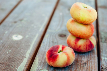 Fresh Saturn peaches on old board