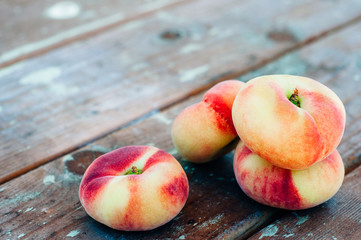Fresh Saturn peaches on old board