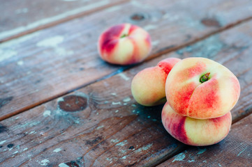 Fresh Saturn peaches on old board