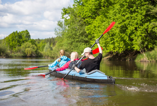 Young people are kayaking on a river in beautiful nature