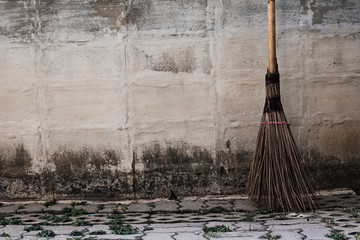 Broom / A broom made of coconut leaf core lying the wall