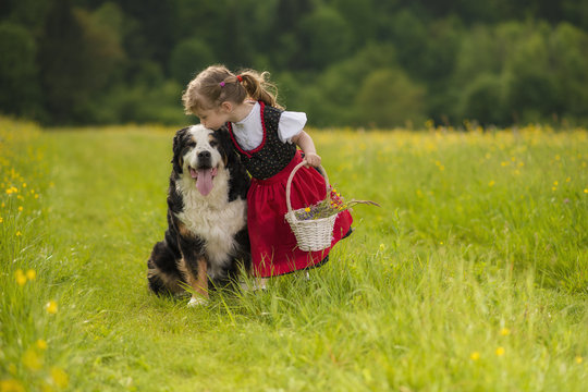 Bambina nel campo di fiori con gerla