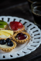 Fresh fruits tarltlets pastry with cream on plate