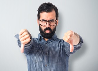 Young hipster man doing bad signal