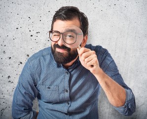 Young hipster man with magnifying glass