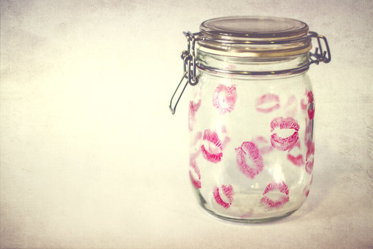 Close-up of an empty Glass jar covered in pink lipstick kisses