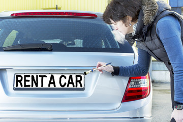 Woman writes with a brush on the sign of cars