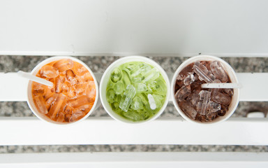 Ice green Tea and Ice coffee on a white wood background.