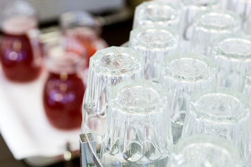 topsy-turvy glasses on counter with gugs of red drink