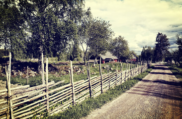 Fototapeta premium old farms and wooden fences in a rural landscape, Sweden