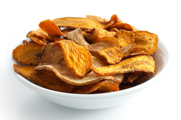 Bowl of fried carrot and parsnip chips. Isolated on white.